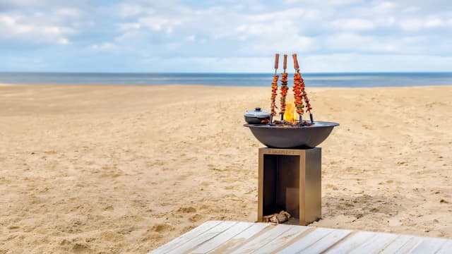 Tiger Fire vuurschaal met spiesen boven het vuur op het strand